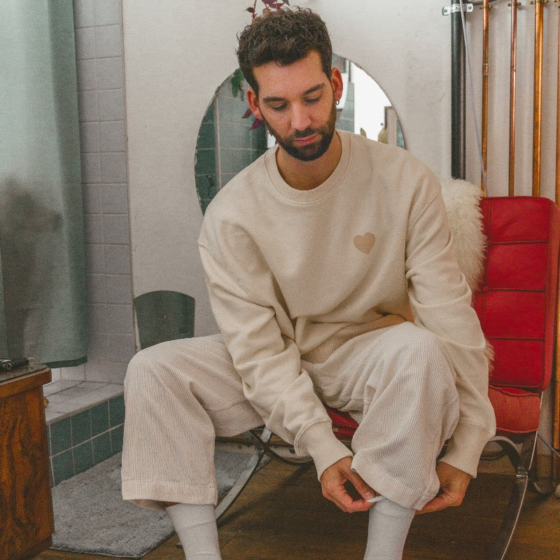 Beige sweater met beige hartje op de voorkant en oranje tekst in puff inkt op achterkant