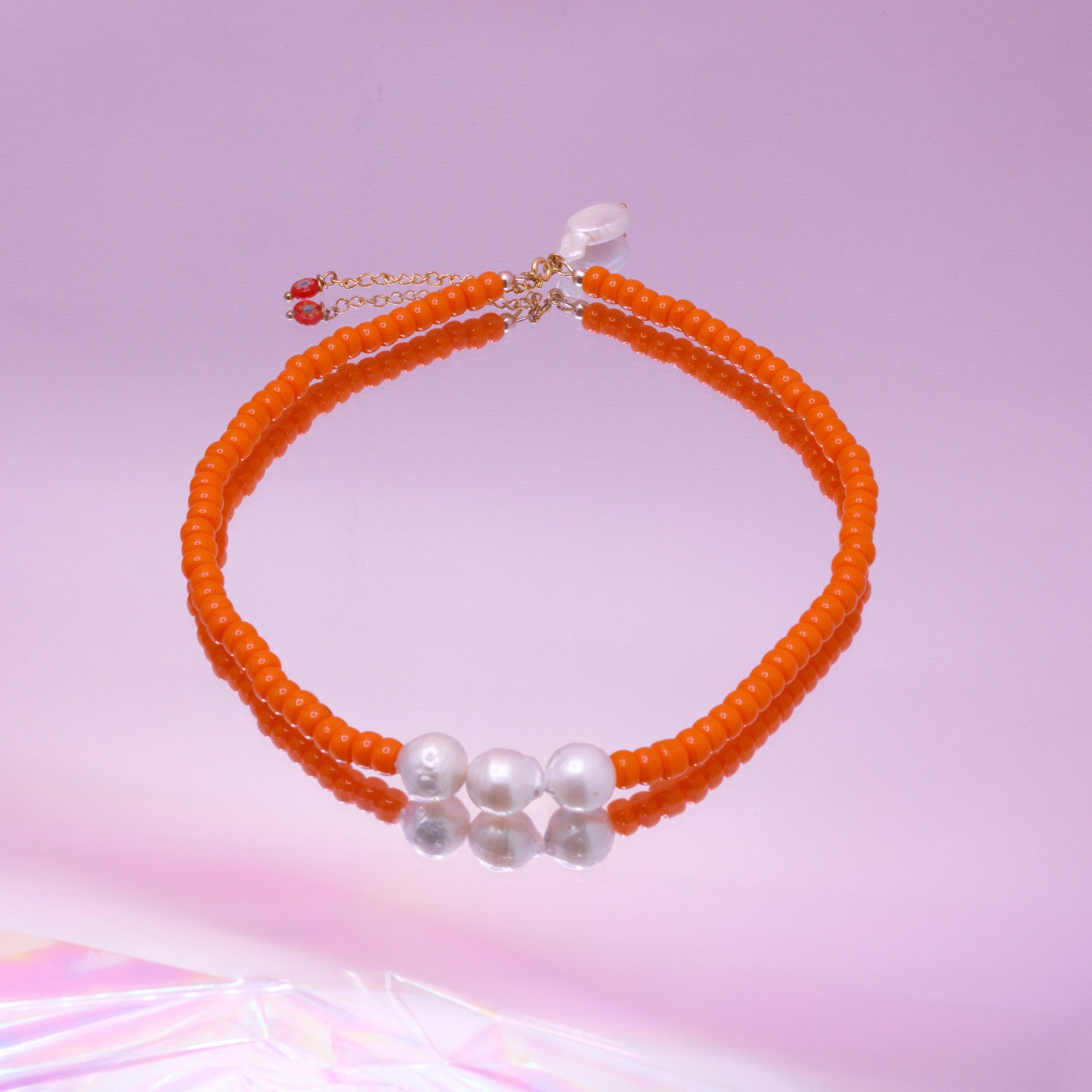 Ketting met fel oranje glaskralen en zoetwaterparels